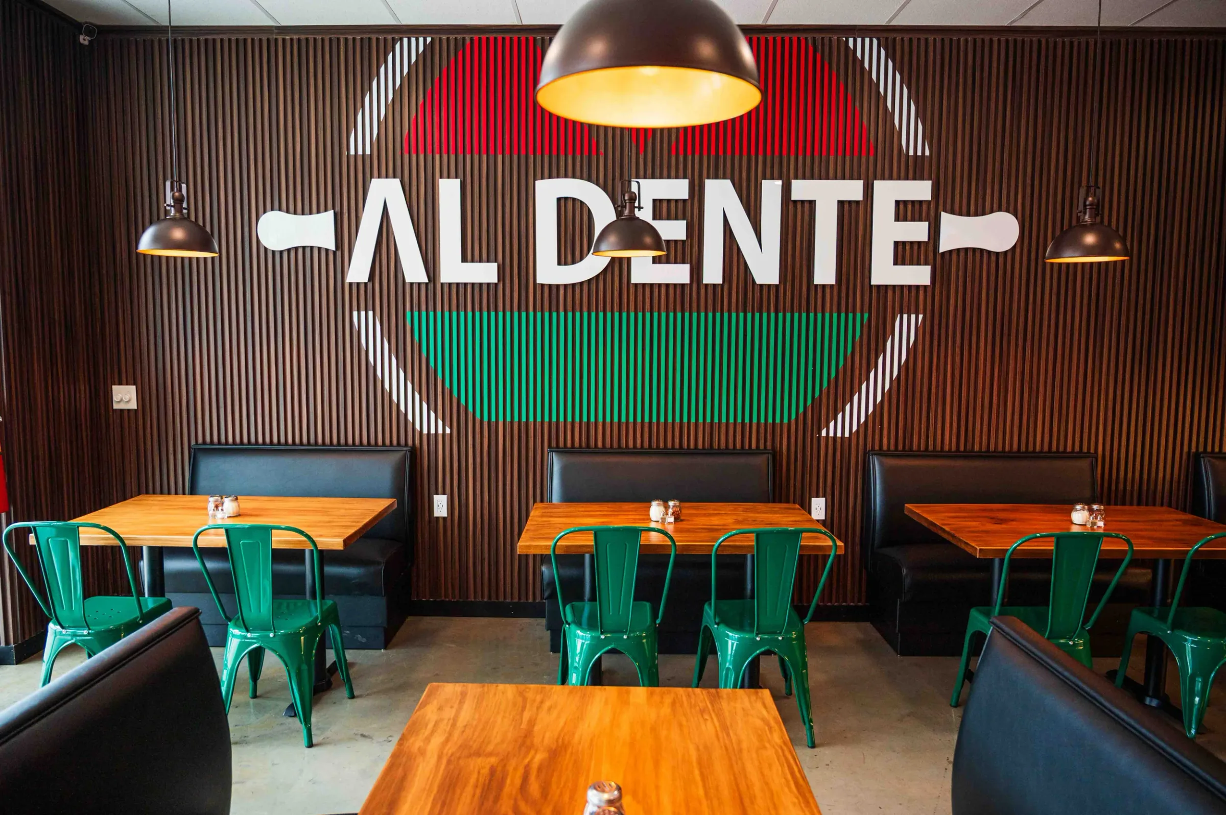 The Hoschton dining room, with the Al Dente logo painted large across the slatted wood wall above the booths