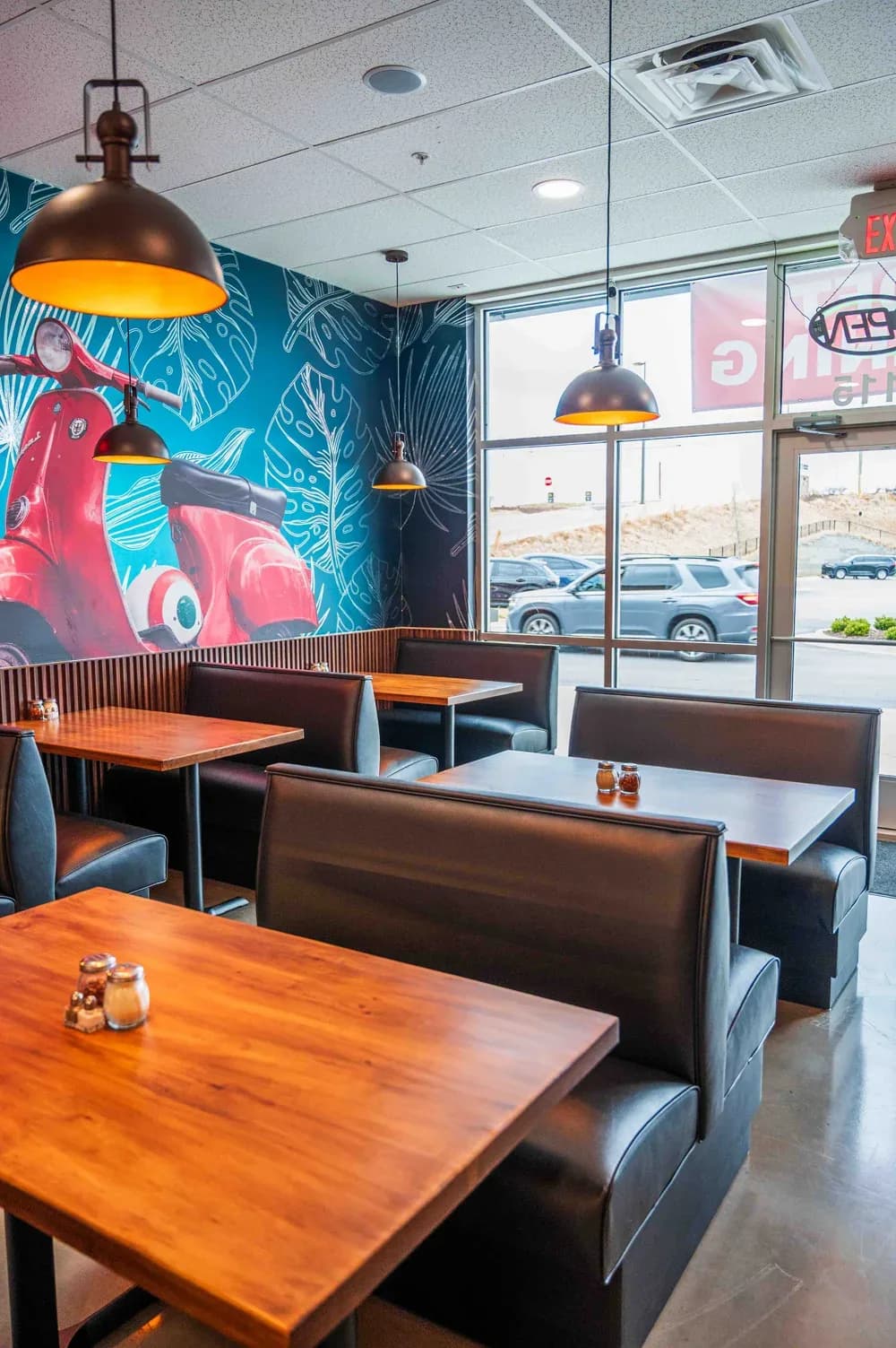 The red Vespa parked inside the Hoschton dining room, under the mural