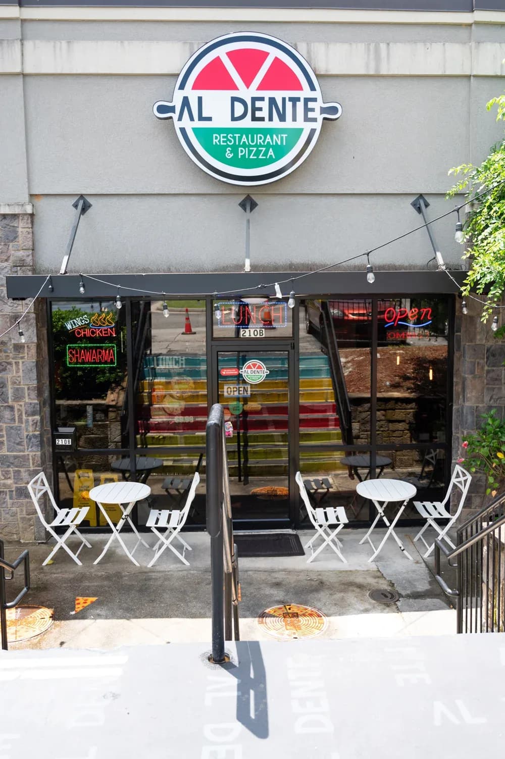 The Al Dente storefront in Duluth, with the round sign above the door and tables out front